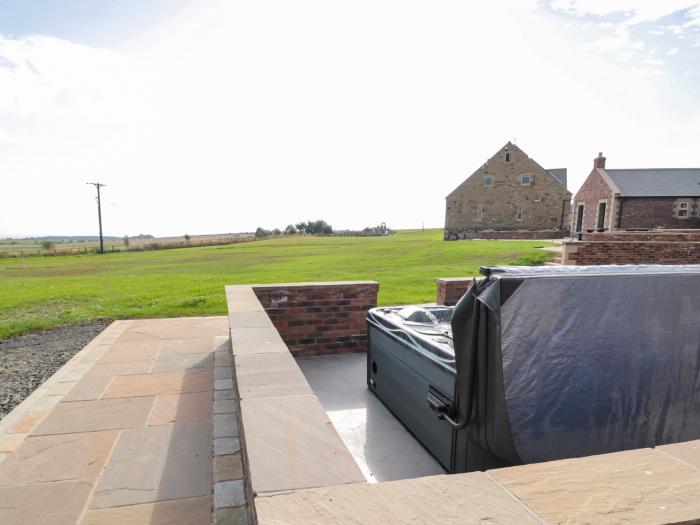 Byre Cottage in Embleton, Northumberland. Single-storey. Child-friendly. Spacious patio with hot tub