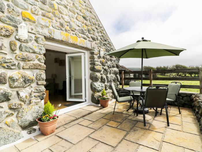 Beudy rests in Dyffryn Ardudwy, in Gwynedd. Two-bedroom home near beach and amenities. Private patio